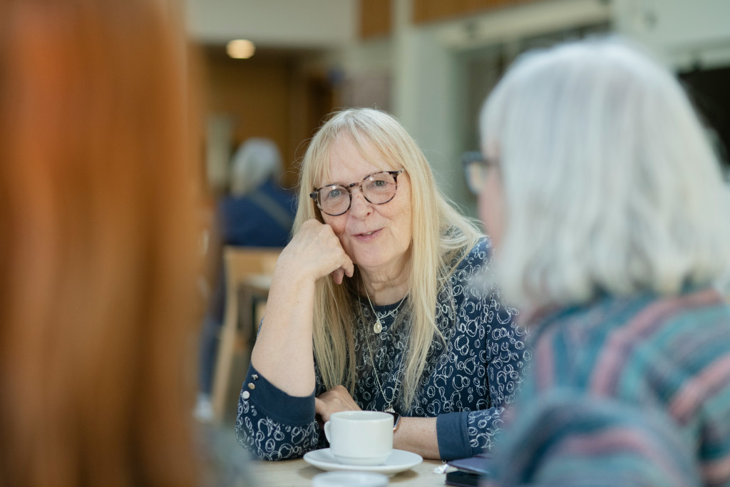 Woman in glasses sat talking with friends